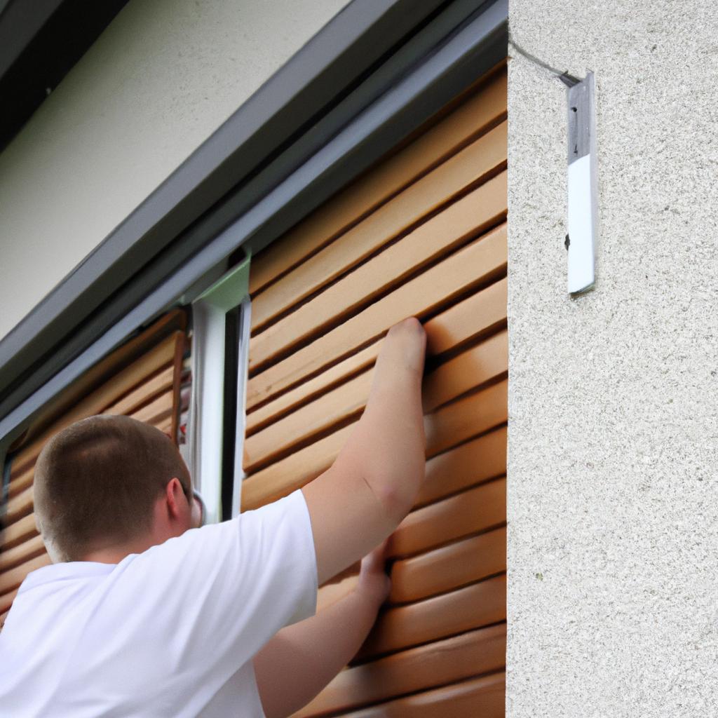 Person installing exterior hardboard shutters